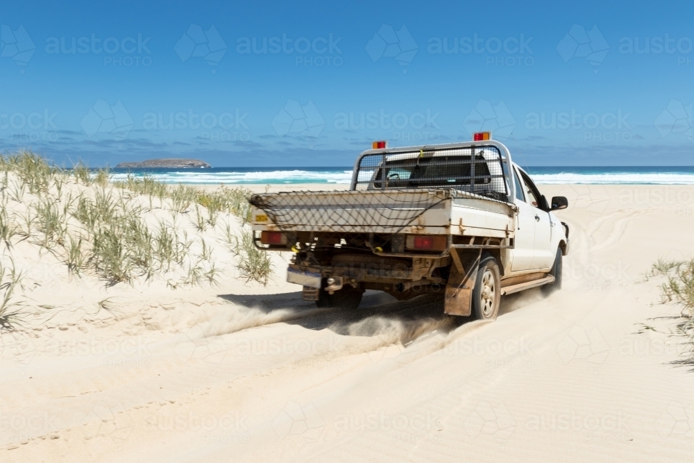 Four wheel drive ute driving onto beach - Australian Stock Image