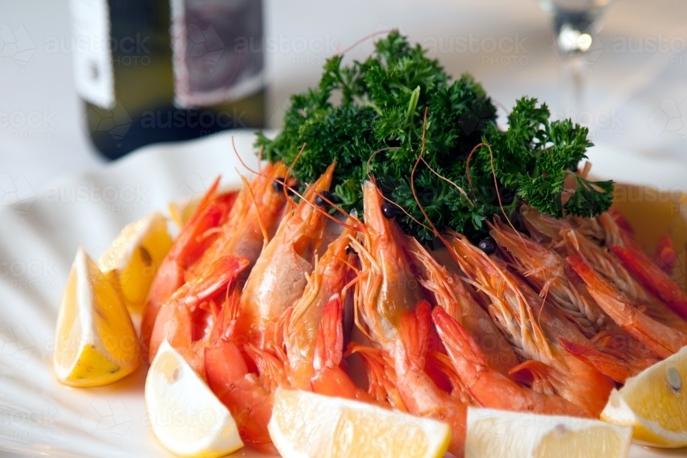 Fresh prawns arranged on a plate with lemon slices - Australian Stock Image