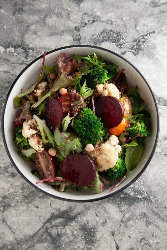 Fresh salad in bowl on marble table - Australian Stock Image