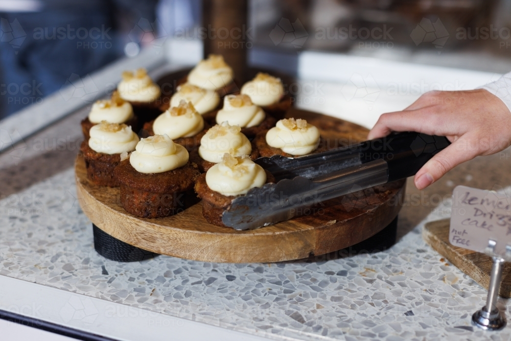 Freshly baked cupcakes with swirl frosting served in a wooden board. - Australian Stock Image