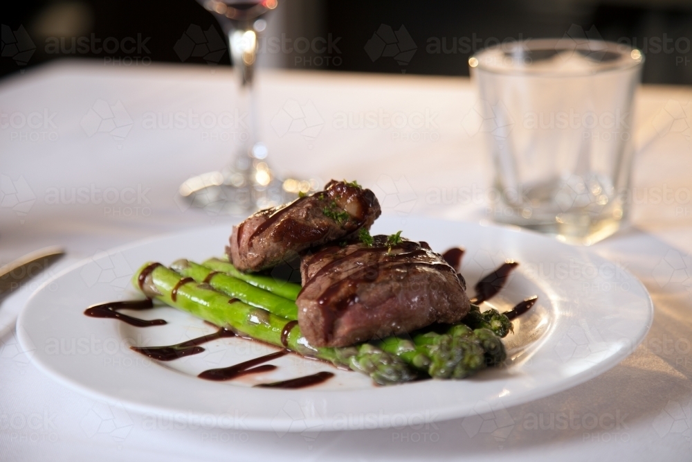 Freshly cooked steak on a plate with asparagus - Australian Stock Image