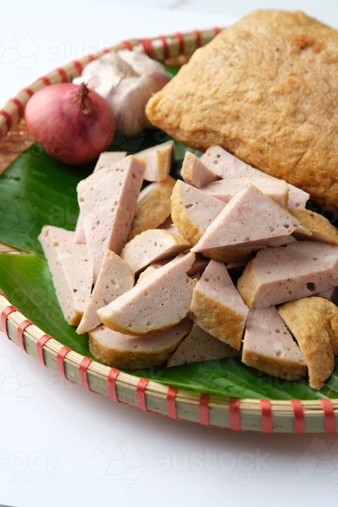 Fried Cha Lua served on a banana leaf inside a woven basket - Australian Stock Image