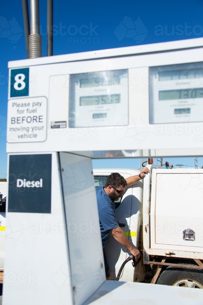 Fuel bowser and man filling ute with diesel - Australian Stock Image