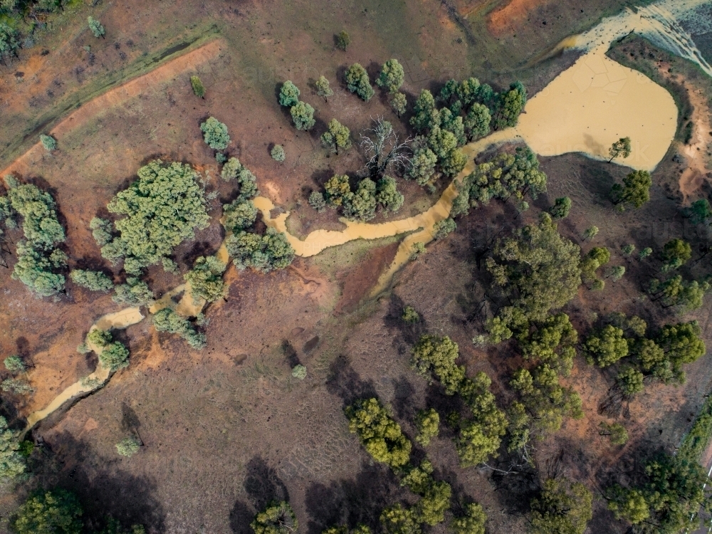 Full creek and overflowing dam in rural paddock - Australian Stock Image