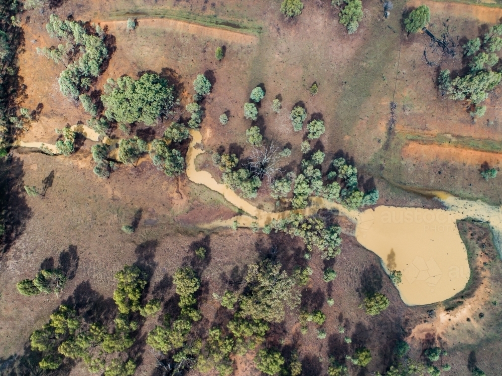 Full creek and overflowing dam in rural paddock - Australian Stock Image