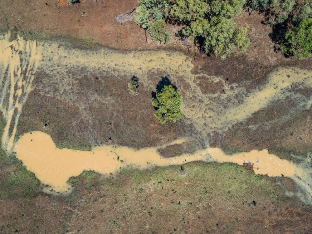 Full creek and overflowing dam in rural paddock - Australian Stock Image