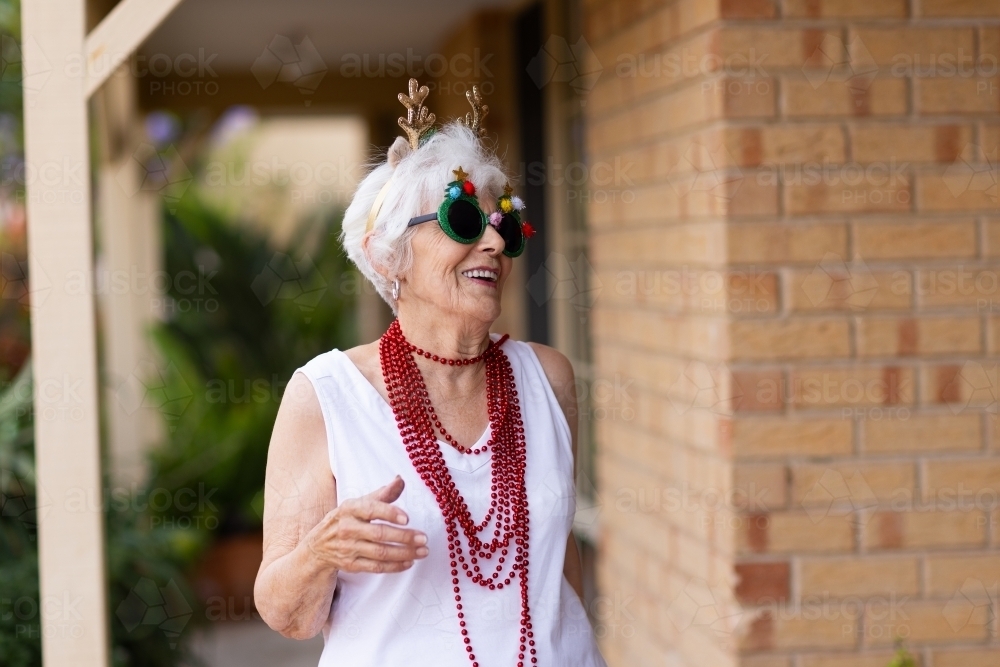 fun-loving octogenarian having fun dressed up fancy for Christmas - Australian Stock Image