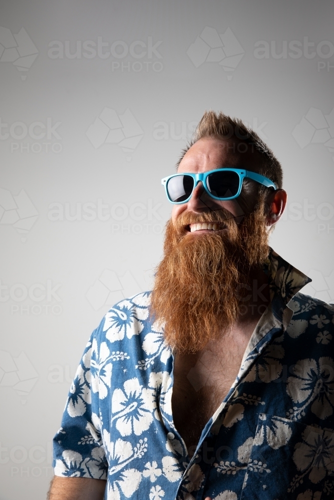 Funky man in a blue floral shirt posing for photographs - Australian Stock Image