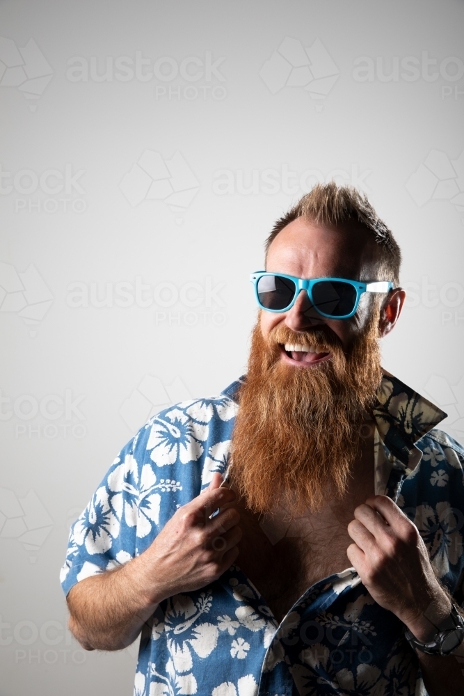 Funky man in a blue floral shirt posing for photographs - Australian Stock Image