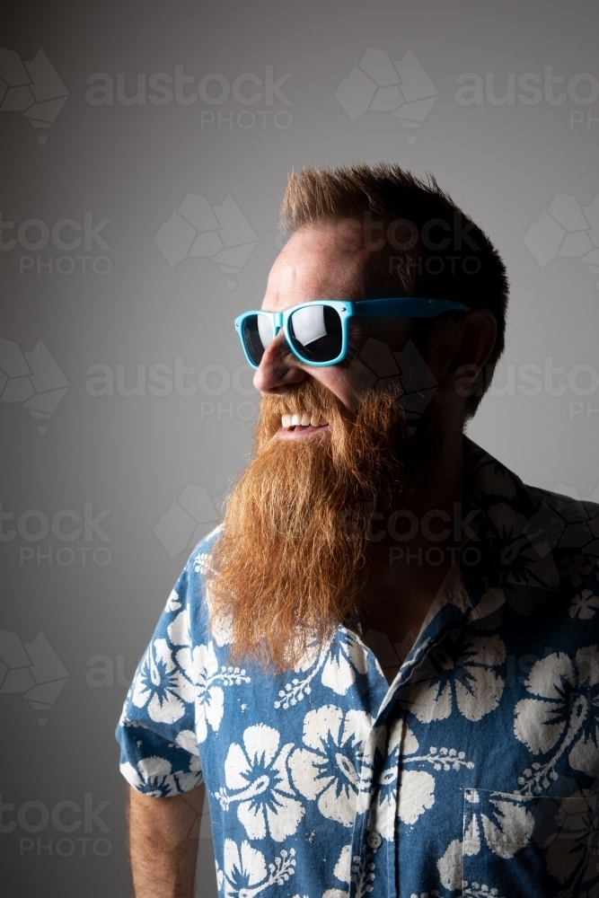 Funky man in a blue floral shirt posing for photographs - Australian Stock Image