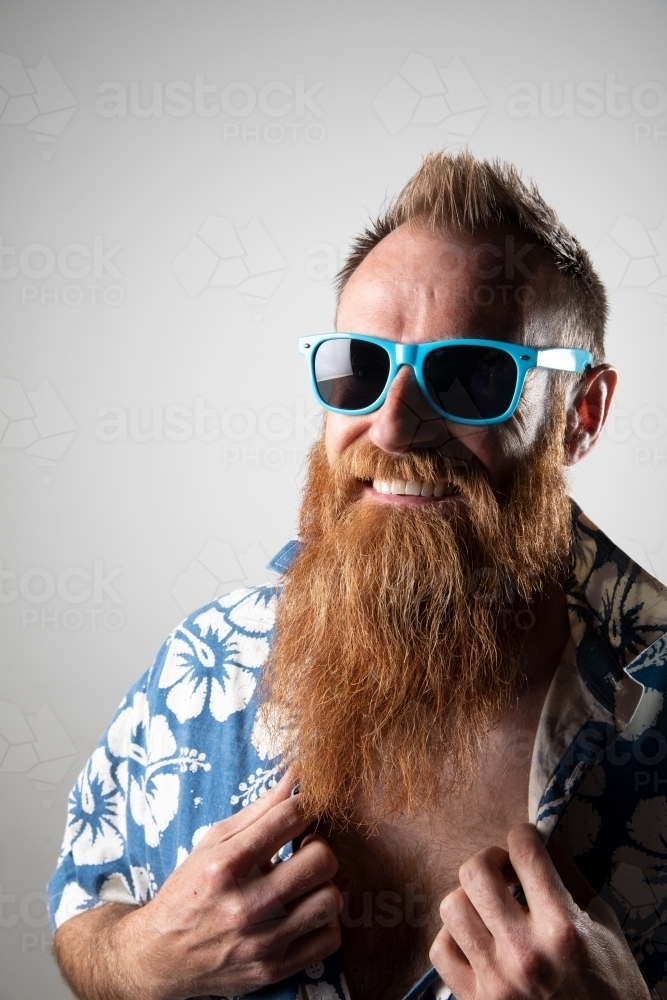 Funky man in a blue floral shirt posing for photographs - Australian Stock Image