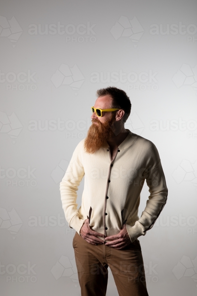 Funky man posing for photographs, wearing a beige shirt - Australian Stock Image