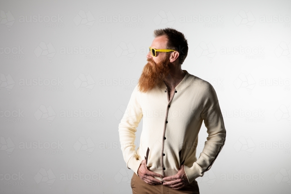 Funky man posing for photographs, wearing a beige shirt - Australian Stock Image