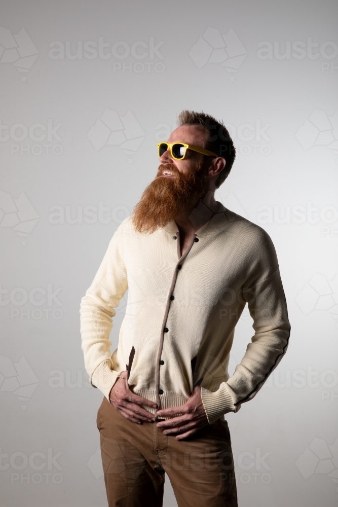 Funky man posing for photographs, wearing a beige shirt - Australian Stock Image