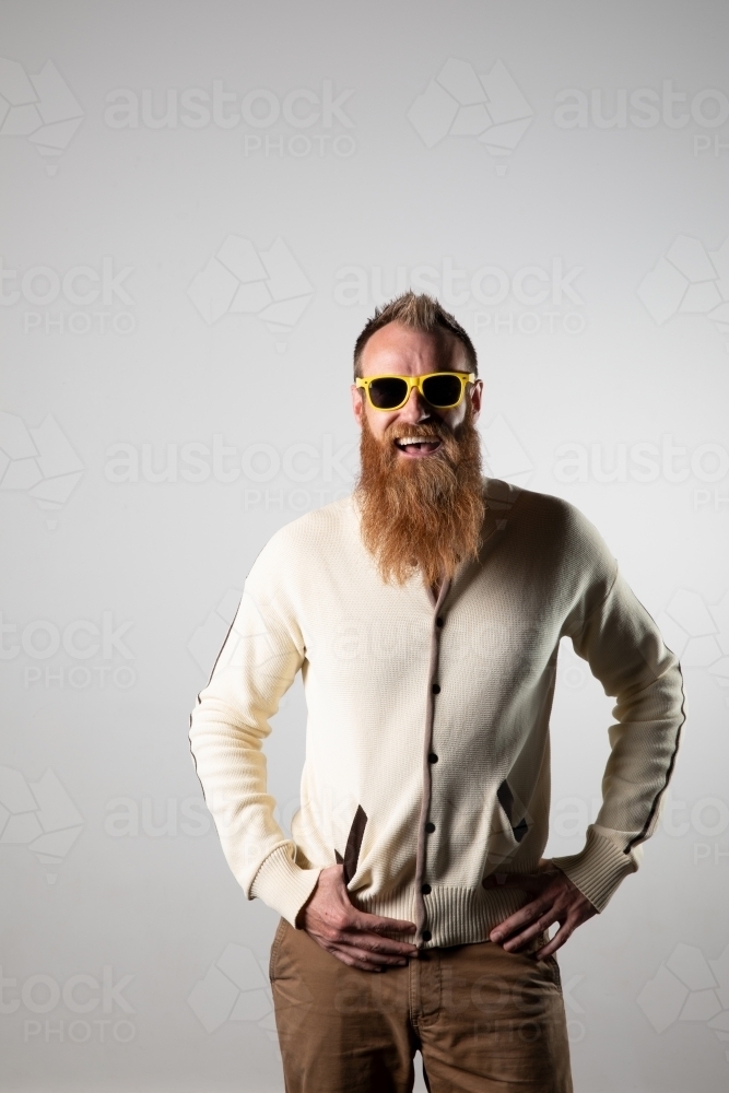 Funky man posing for photographs, wearing a beige shirt - Australian Stock Image