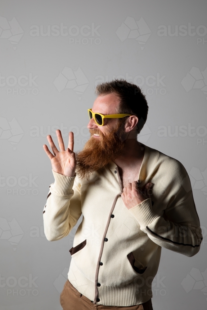 Funky man posing for photographs, wearing a beige shirt - Australian Stock Image