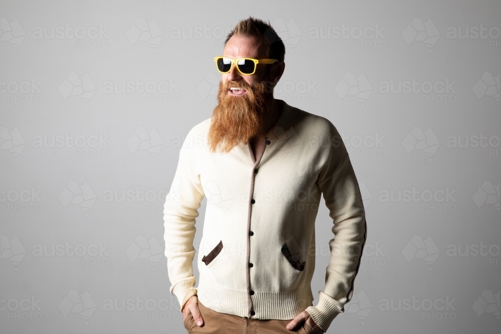 Funky man posing for photographs, wearing a beige shirt - Australian Stock Image