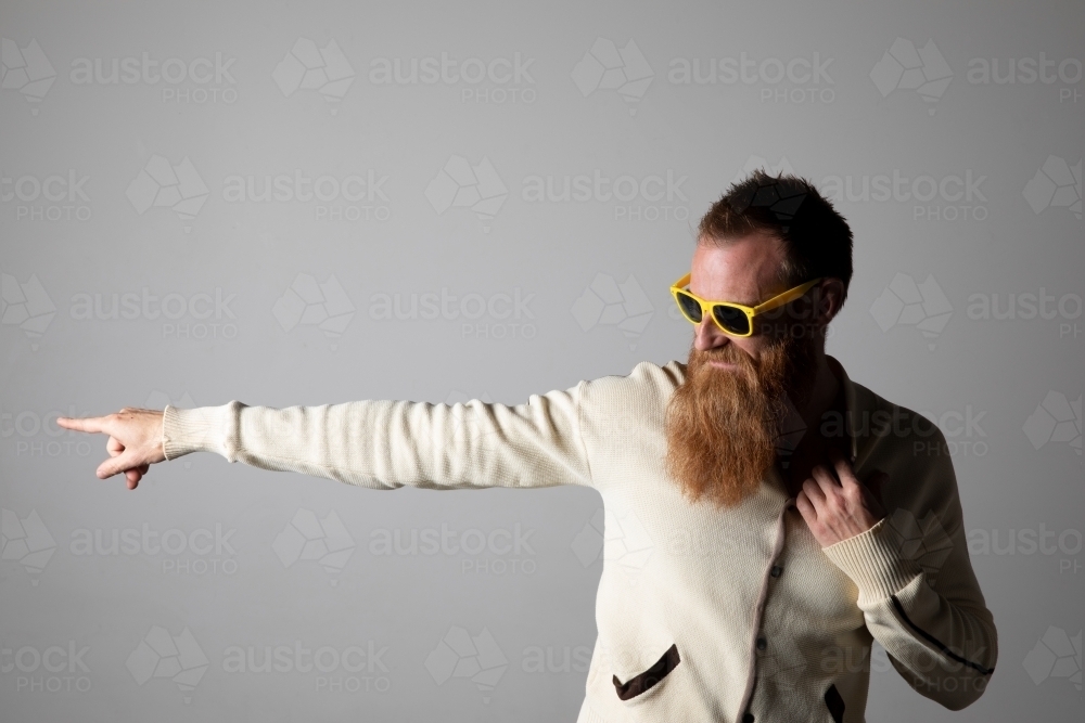 Funky man posing for photographs, wearing a beige shirt - Australian Stock Image