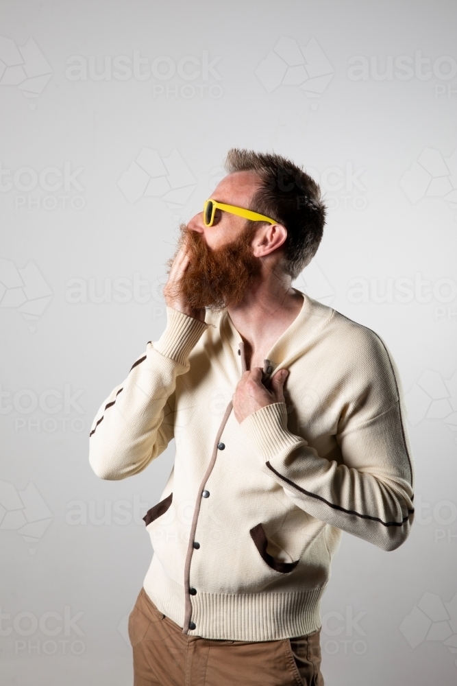 Funky man posing for photographs, wearing a beige shirt - Australian Stock Image