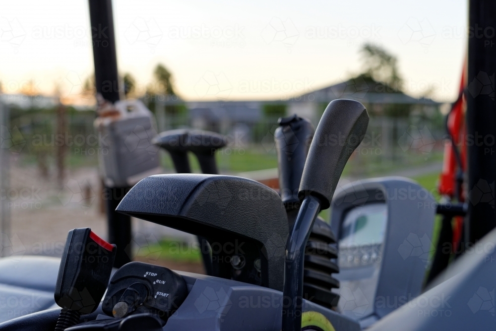 Gear levers and equipment on inside of mini excavator digger - Australian Stock Image