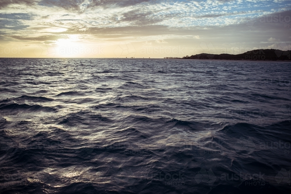 Gentle ripples and waves of the sea with a visible horizon - Australian Stock Image