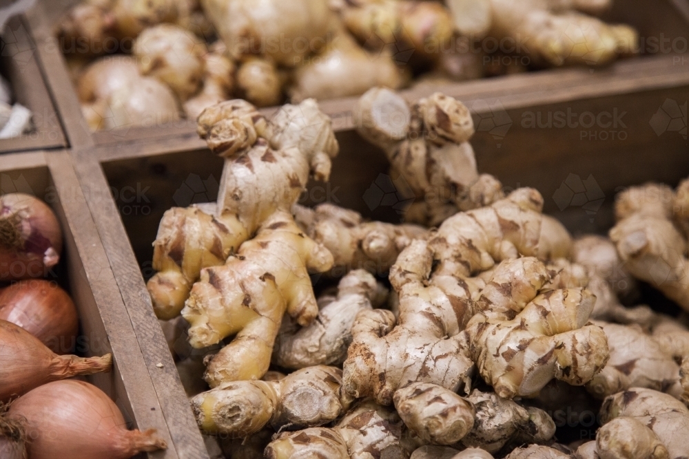 Ginger in wooden box at market stall - Australian Stock Image