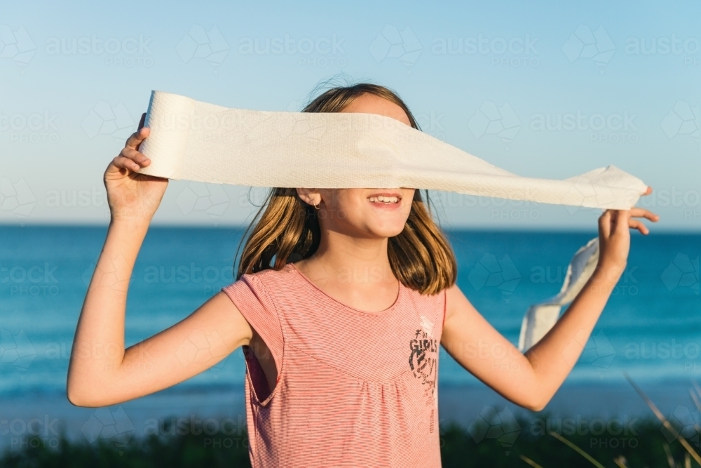 girl being silly with toilet paper, making a blindfold - Australian Stock Image