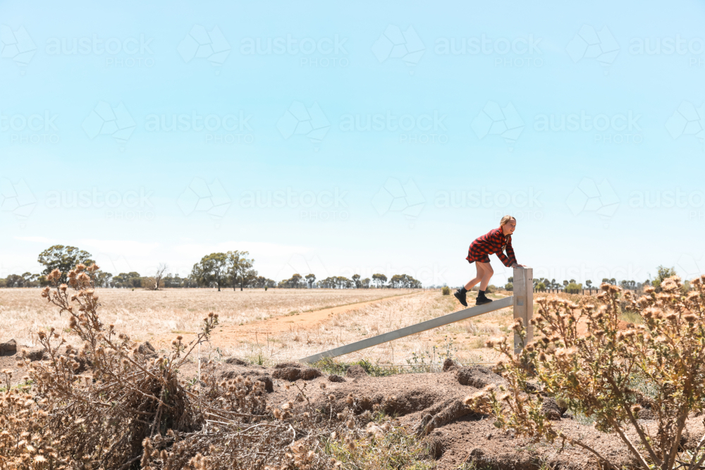 Girl climbing on fence in rural Australia - Australian Stock Image