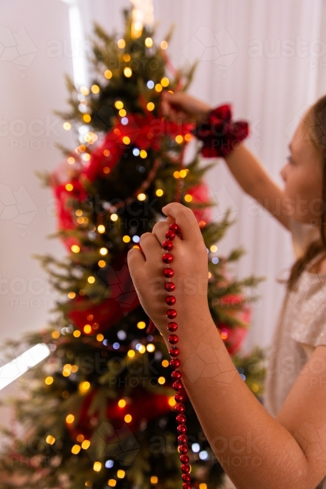 girl concentrating on Christmas decorating - Australian Stock Image