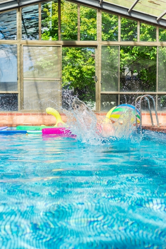 girl doing bomb dive into a swimming pool - Australian Stock Image