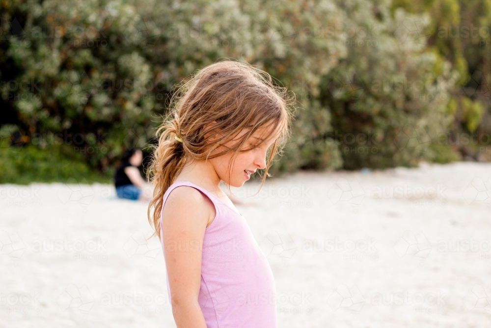 Girl facing down on the beach - Australian Stock Image