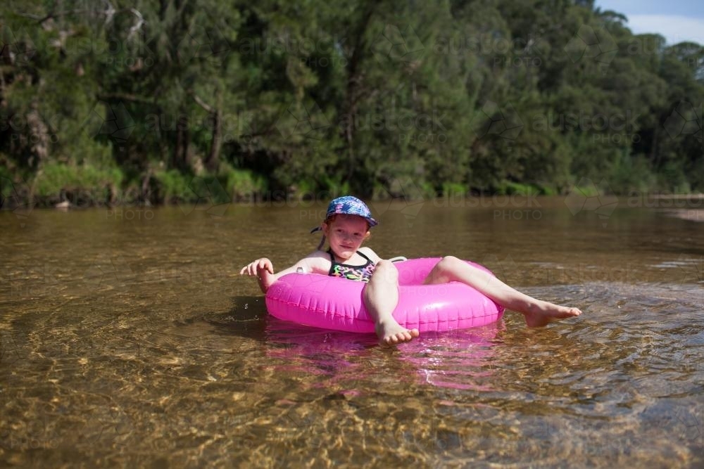 Girl floating on a river in an inflatable ring - Australian Stock Image