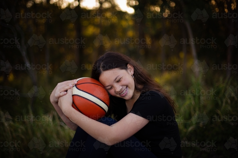 girl hugging basketball - Australian Stock Image