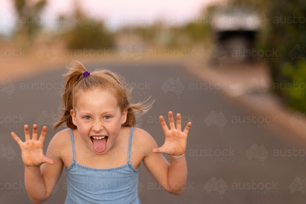 girl outside making scary face with hands like claws - Australian Stock Image