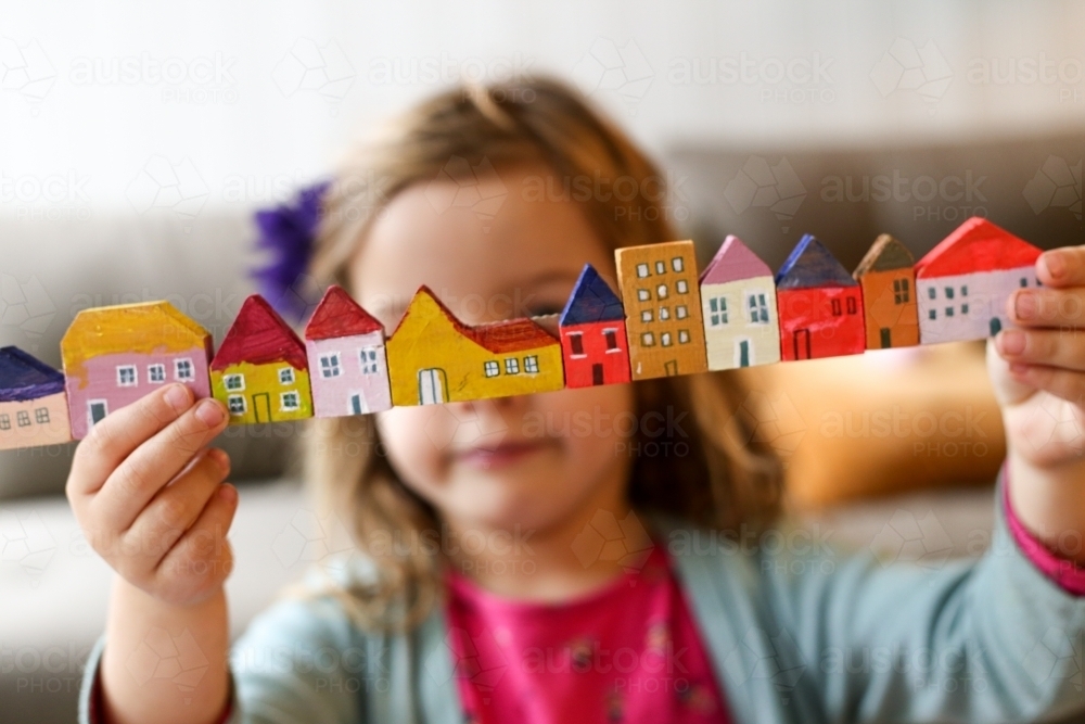 Girl playing with coloured in house blocks - Australian Stock Image