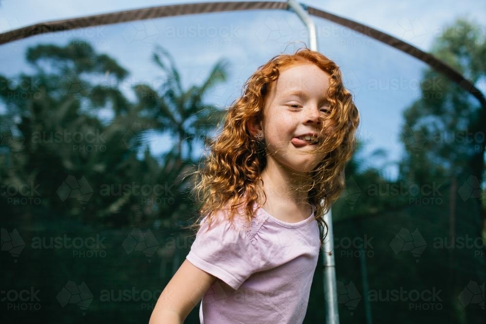Girl ready to jump from the edge of a trampoline - Australian Stock Image