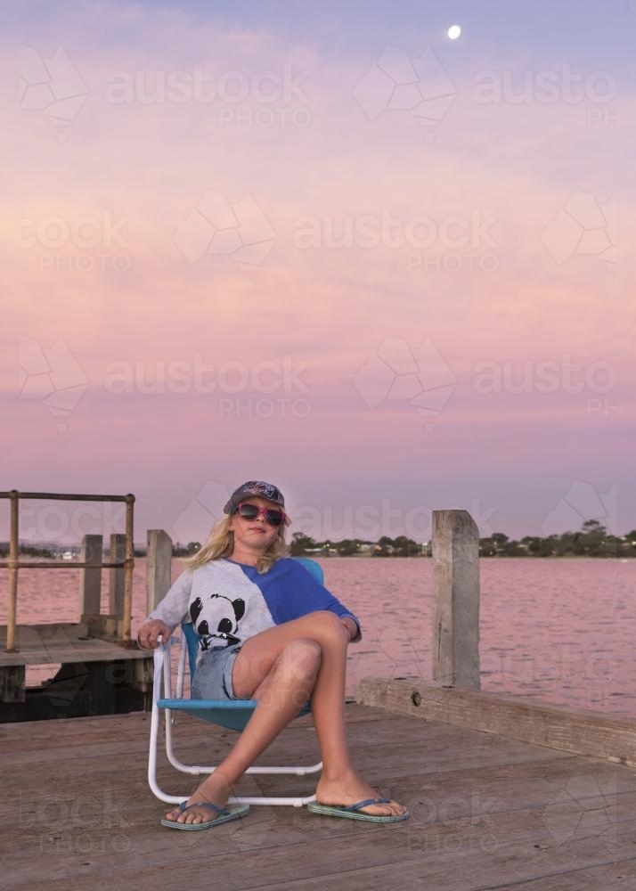 Girl Relaxing Under Pink Sunset with Moon - Australian Stock Image