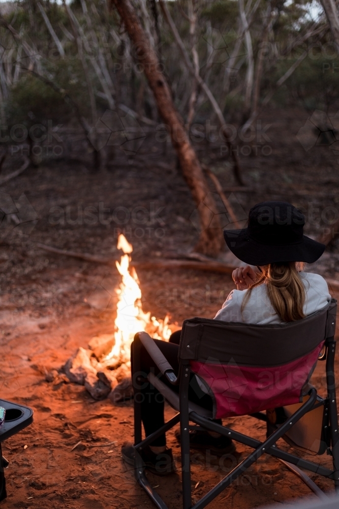 Girl sitting by campfire - Australian Stock Image