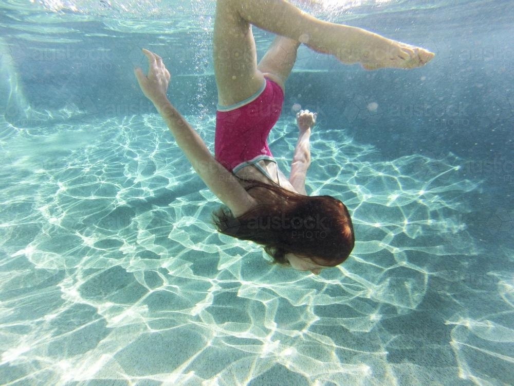 Girl swimming underwater in a pool - Australian Stock Image