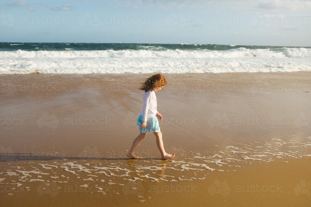 Image Of Girl Walking Along The Shoreline At The Beach Austockphoto