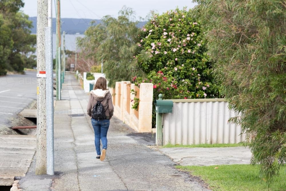 Girl walking down deserted footpath - Australian Stock Image