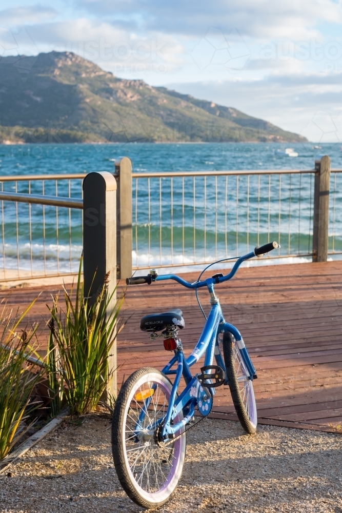 Girls bike standing on viewing deck near ocean and cliffs - Australian Stock Image