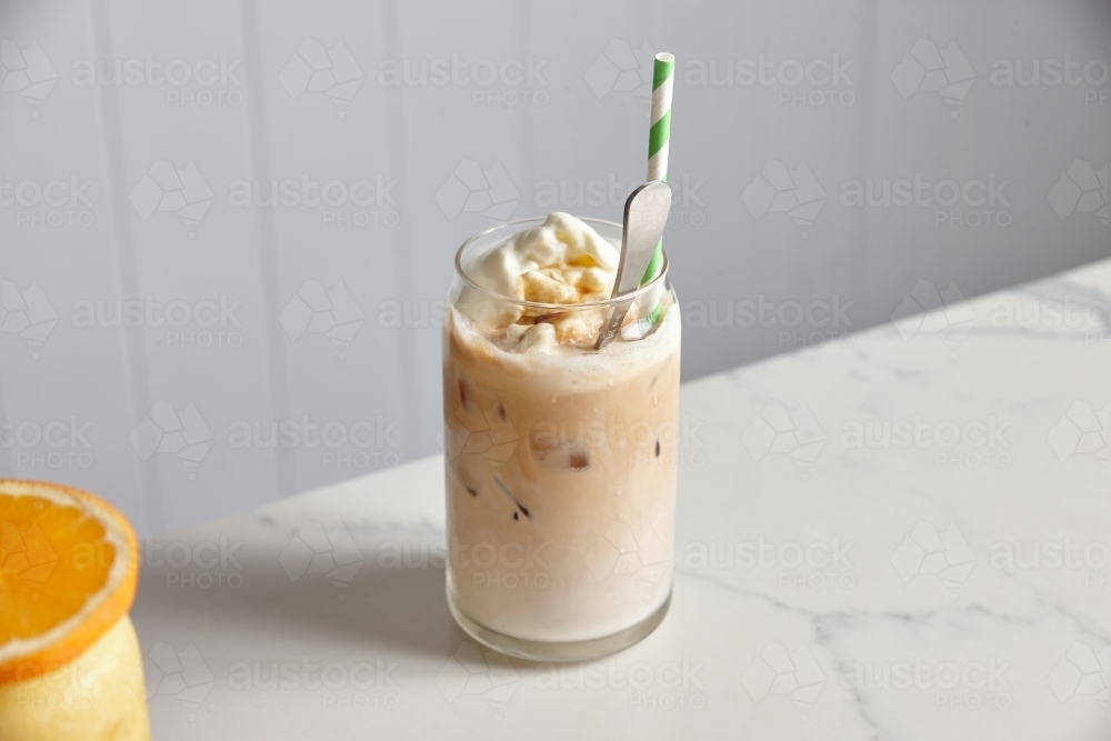 Glass of iced coffee with ice cream, with a glass of orange juice on the side - Australian Stock Image