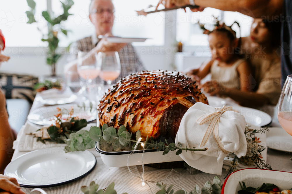 Glazed holiday ham with cloves served for dinner - Australian Stock Image