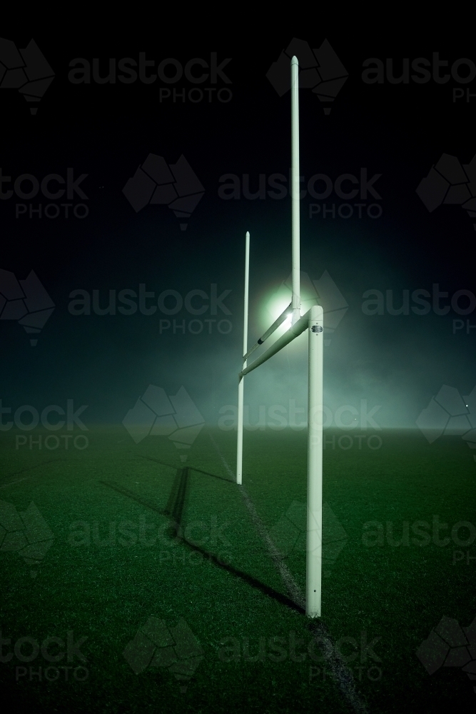 Goal posts on the sports oval in the fog at night - Australian Stock Image