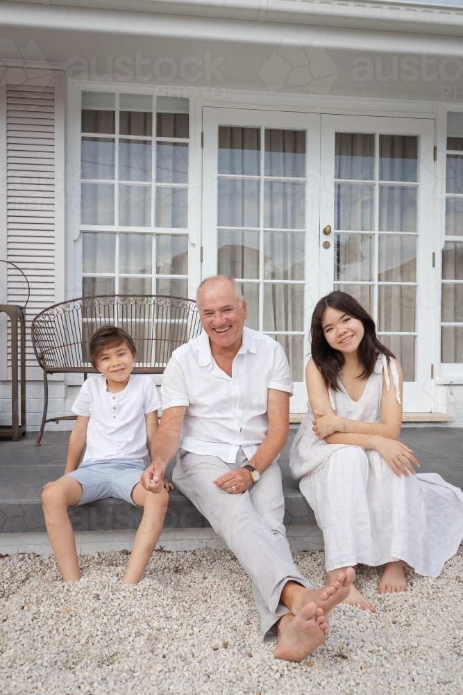 Grandad sitting with grandkids on back deck - Australian Stock Image