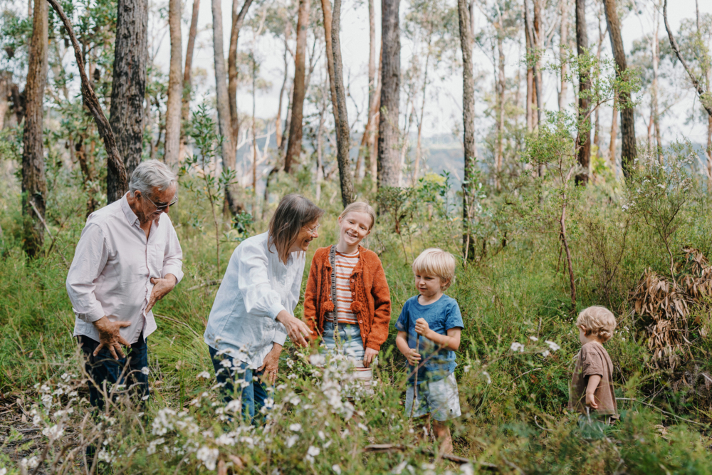 Grandparents enjoying Australian Bushland with their Grandchildren chatting together - Australian Stock Image