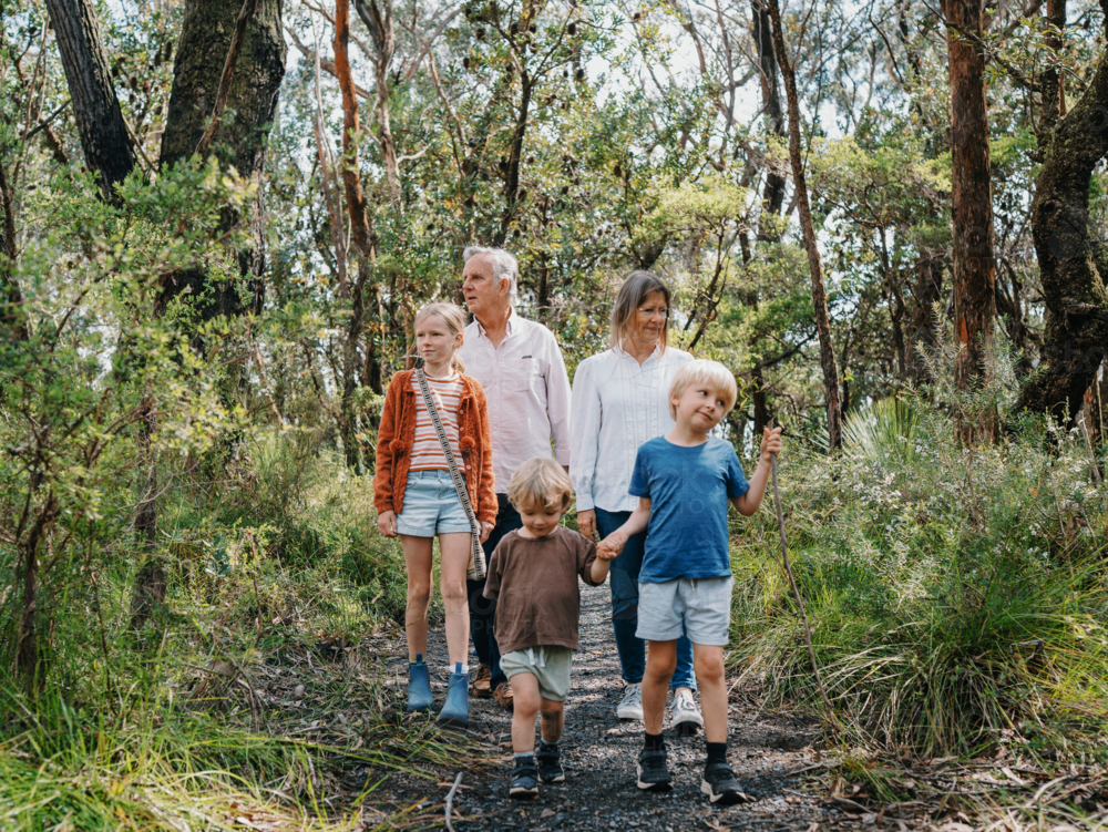 Grandparents enjoying Australian Bushland with their Grandchildren walking along path together - Australian Stock Image