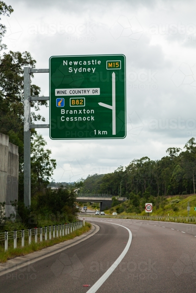 Green road sign showing directions to Newcastle, Sydney on M15 highway - Australian Stock Image