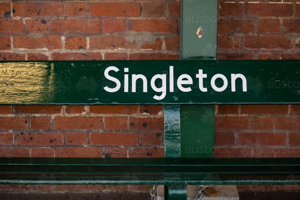 Green seat saying Singleton on the platform at the train station - Australian Stock Image